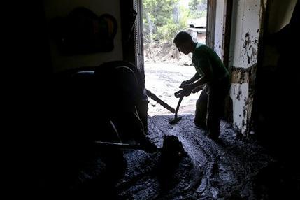 Un hombre saca barro de su casa en Santiago