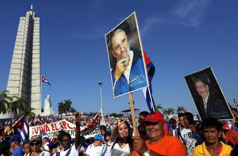 Jovenes ingresan con afiches de Fidel Castro en la Plaza de la Revolución
