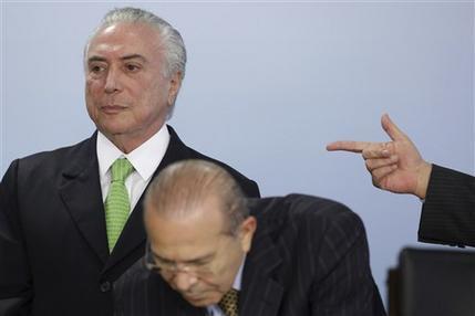 Michel Temer está de pie detrás del secretario de la presidencia Eliseu Padilha en el palacio presidencial de Planalto, ayer