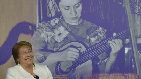 Bachelet, frente a un poster de la folclorista Violeta Parra. 