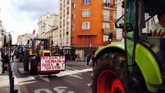 Tractores con agricultores en las calles de Paris luego de arrojar  arrojar estiércol y basura frente a supermercados