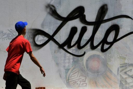 Un joven pasa delante de un graffiti en Tegucigalpa, capital de Honduras