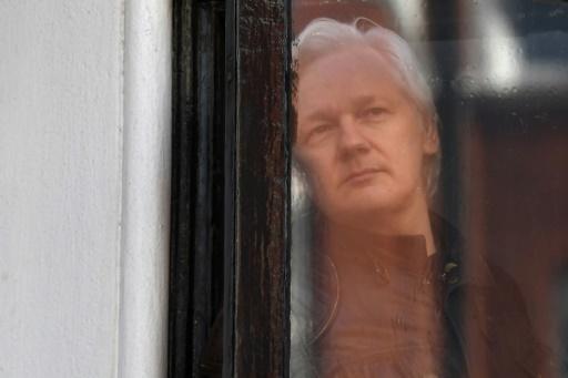  Julian Assange, mira por una ventana de la embajada de Ecuador en Londres,