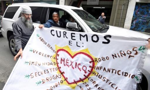  Andrés Manuel López Obrador, sostiene una pancarta desde un automóvil, ayer