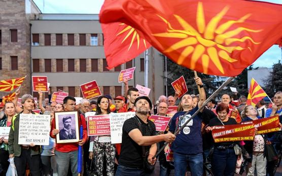 Un hombre hace ondear una bandera de Macedonia durante una manifestación contra la propuesta de nuevo nombre para el país