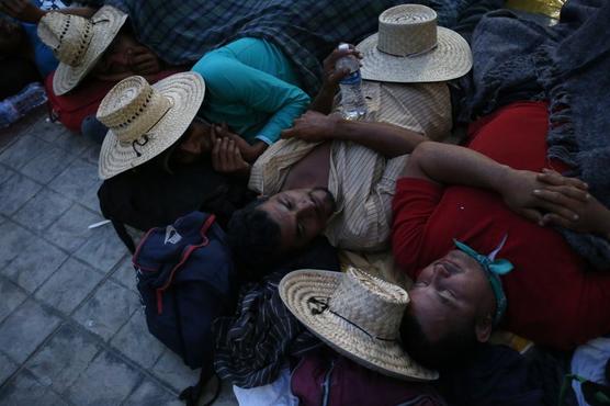Migrantes agotados duermen juntos en una iglesia anoche