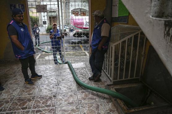 Empleados del Sistema de Aguas de la Ciudad de México llenan la cisterna de un edificio