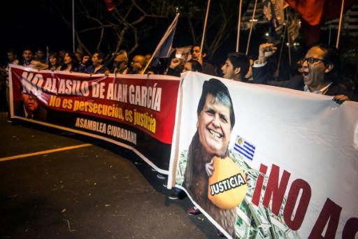 Manifestantes con carteles contra el expresidente peruano Alan García.