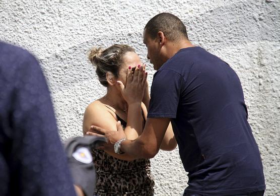 Madre desconsolada frente a la escuela pública Raul Brasil en Suzano, Brasil