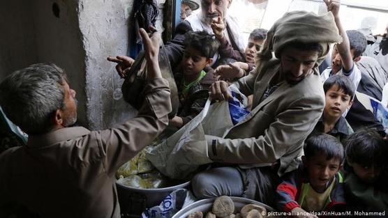 Residentes de Saná, Yemen, reciben alimentos en un centro de distribución