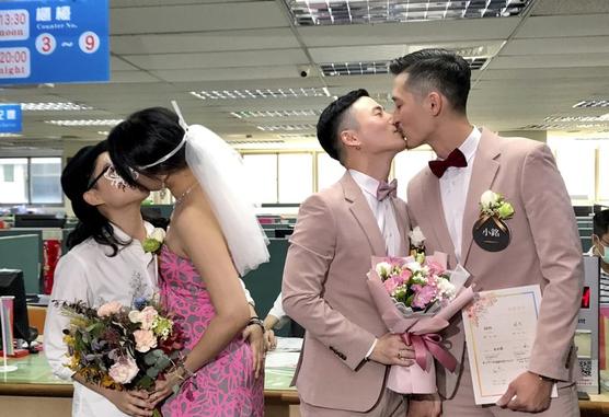 Dos parejas homosexuales sellan su matrimonio legal con un beso en una oficina de registro en el distrito de Xingyi, en Taipei