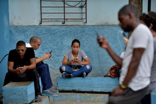 Cubanos se conectan a Internet mediante una señal de wifi en un área pública de La Habana