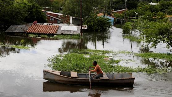 Un hombre rema en una calle inundada de Asuncion