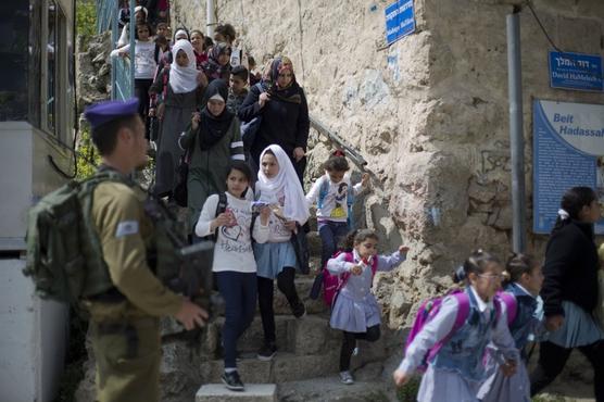 Un soldado israelí vigila el regreso de niños palestinos que van a la escuela en el sector de Hebrón (Cisjordania) 