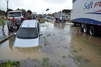 Un vehículo yace atascado en un agujero provocado por las lluvias en el vecindario de Tabajara, en la ciudad de Recife