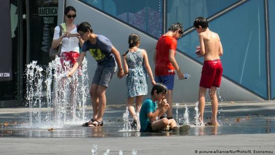 Chicos se refrescan en una fuente de Berlín