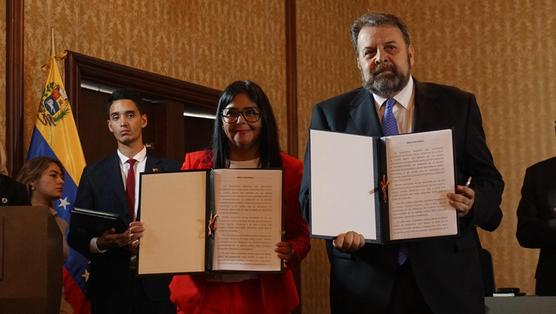 Delcy Rodríguez, vice-presidenta de Venezuela y el diputado opositor Timoteo Zambrano muestran el acuerdo firmado el lunes 
