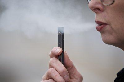 Una mujer exhalando vapor de un cigarrillo electrónico Juul en Vancouver, Washington.