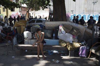 Una mujer se sienta junto a sus pertenencias durante un desalojo en la favela de Mangueira en Río de Janeiro