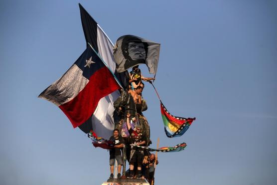 Manifestantes ondean la bandera de Chile y la Mapuche en protesta contra el gobierno de Piñera, en Santiago el viernes