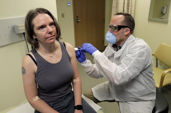 Un farmacéutico aplica a Jennifer Haller la primera dosis de una prueba clínica para una posible vacuna contra el COVID-19