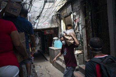 habitante de favela acarrea bolsa con desinfectanes
