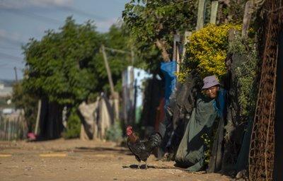 Una mujer se protege mientras la policía patrulla en las afueras de Johanesburgoa