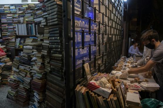 Voluntarios arman la mesa para repartir viandas en la vereda de la librería Diomedes de Montevideo