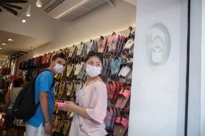 Clientes usan mascarillas, en medio de los temores por el coronavirus, en una tienda en Río de Janeiro