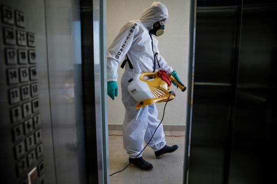 Un trabajador desinfecta un edificio en Santiago de Chile