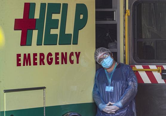 Una enfermera  descansa la cabeza en una ambulancia en una zona de emergencias saturada en el hospital San José en Santiago