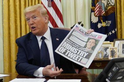 Trump sostiene una edición del New York Post antes de firmar el decreto limitador