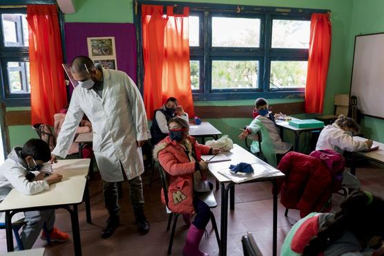 Cubierto su rostro  un maestro dirige su clase en el primer día de vuelta a la escuela rural cerca de Empalme Olmos, Uruguay