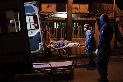 Camilleros suben un anciano a una ambulancia  en Manacapuru