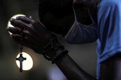 Un médico reza en una iglesia de Río de Janeiro (foto: ANSA)