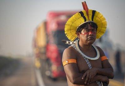 Un indígena kayapo bloquea la autopista BR-163 con otros manifestantes, en donde camiones están parados cerca de Nuevo Progresso