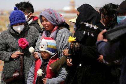 Una familia asiste al funeral de un pariente que falleció por coronavirus en el cementerio El Alto, La Paz