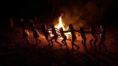 Niños de la tribu brasileña de los Tenetehara juegan alrededor de una fogata durante un festival en la Tierra Indígena Alto Río 
