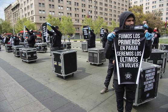 Miembros de la Asociación Gremial de Trabajadores de las Artes y Espectáculos de Chile, exhiben consignas durante una protesta