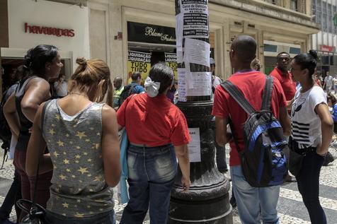 Desocupados mira ofertas de trabajo en un poste en Brasil (foto: ANSA)