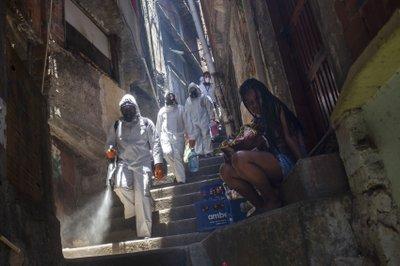 Voluntarios rocían desinfectante en un callejón para ayudar a contener la propagación del nuevo coronavirus en Rio