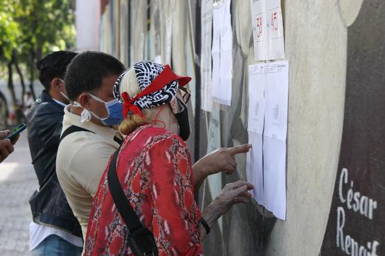 Votantes buscan su lugar en los padrones exhibidos en los lugares de votación