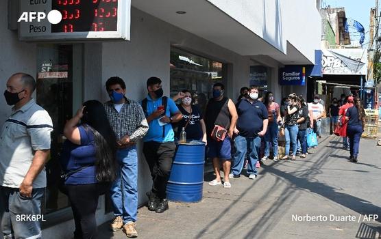 La gente hace cola fuera de un banco en Asunción