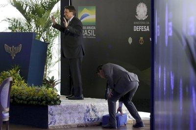  Bolsonaro sonríe tras tropezar al subir a un podio para dirigirse a generales de las fuerzas armadas
