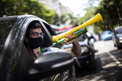  "Fuera, Bolsonaro"  mientras hace sonar una corneta