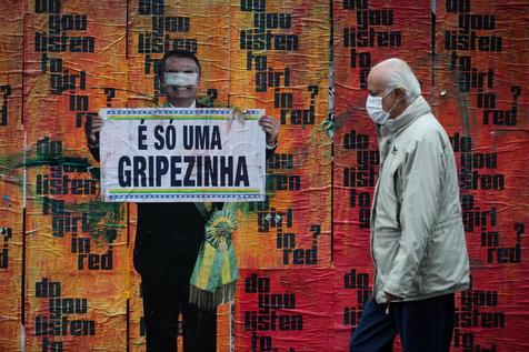 La frase de Jair Bolsonaro subestimando al Covid-19 como una "gripecita" en un mural en la castigada San Pablo (foto: ANSA)