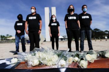 Trabajadores de la salud detrás de un ataúd que representa a colegas muertos durante una protesta contra el presidente de Brasil