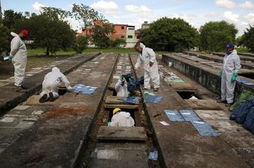 Sepultureros retiran huesos de tumbas viejas en el cementerio de Vila Nova Cachoeirinha