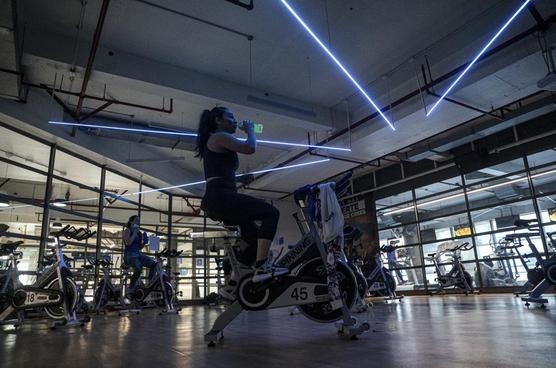 Una mujer  en una clase de spinning en medio de la nueva pandemia de coronavirus, en un gimnasio en Santiago