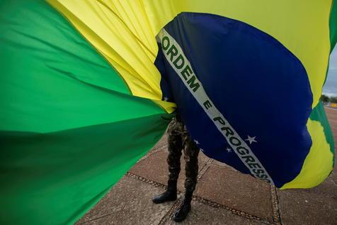 La bandera de Brasil y botas militares, un controvertido símbolo de los tiempos polémicos en el país. (foto: ANSA)